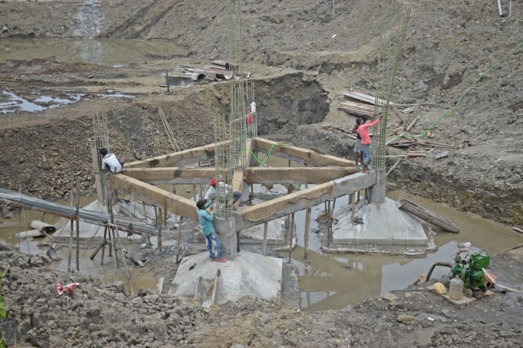 About Workers constructing a building foundation with rebar and wooden supports outdoors.